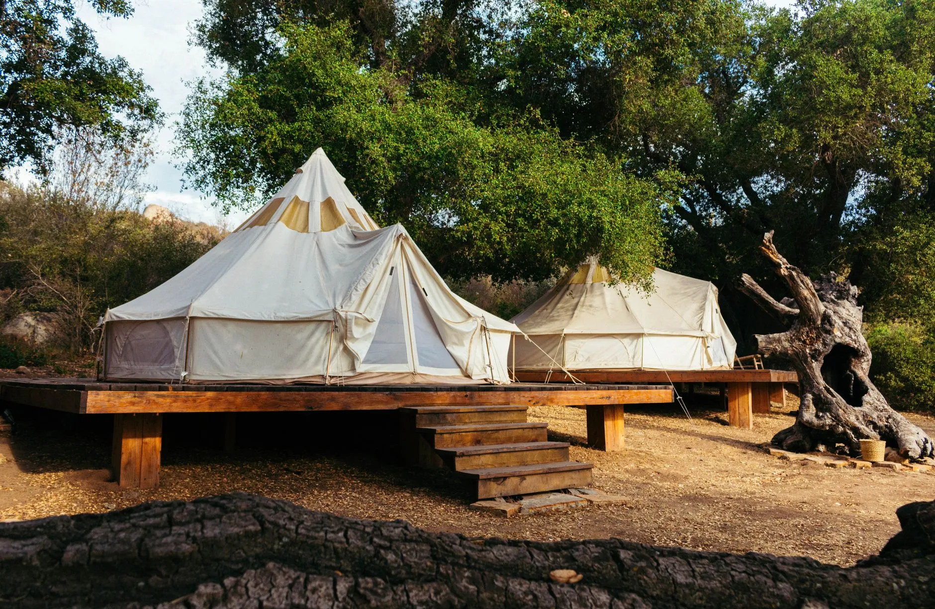Tente lodge installée sur un terrain vallonné, typique des campings glamping du nord de l'Aveyron