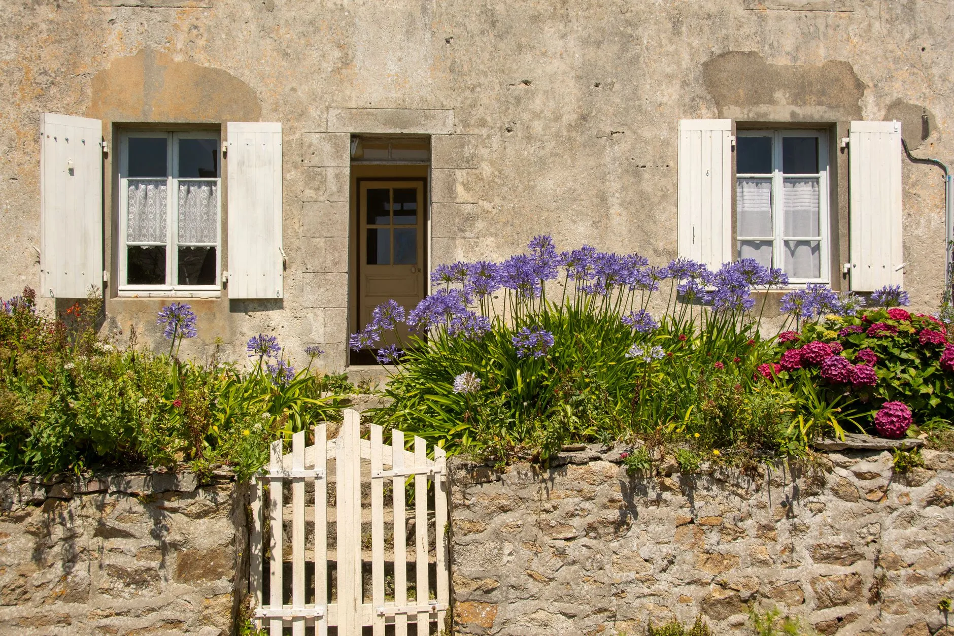 Façade en pierre dans le village circulaire de Gruissan, avec vue sur les étangs